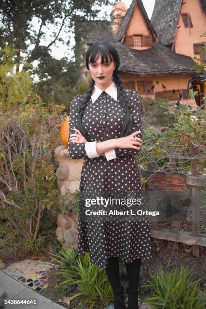 Rachel Pizzolato dressed as Wednesday Addams poses in front of Witches House during Halloween on October 31, 2022 in Beverly Hills, California.