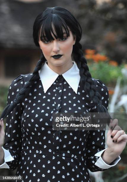 Rachel Pizzolato dressed as Wednesday Addams poses in front of Witches House during Halloween on October 31, 2022 in Beverly Hills, California.
