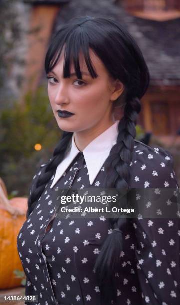Rachel Pizzolato dressed as Wednesday Addams poses in front of Witches House during Halloween on October 31, 2022 in Beverly Hills, California.