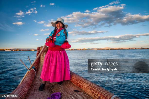 peruano mujer navegación entre islas flotantes de uros, el lago tititcaca - quechuas fotografías e imágenes de stock