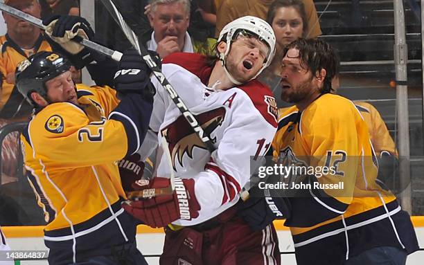 Martin Hanzal of the Phoenix Coyotes takes a shot to the face from Ryan Suter of the Nashville Predators in Game Four of the Western Conference...