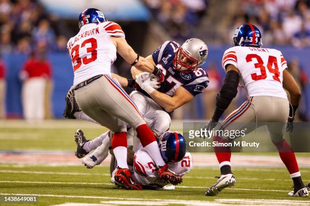Rob Gronkowski of the New England Patriots is tackled by Chase Blackburn, and Kenny Phillips of the New York Giants in the Super Bowl XLVI . The New...