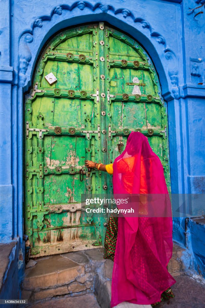Young Indian woman walking inside a Blue City of Jodhpur, India