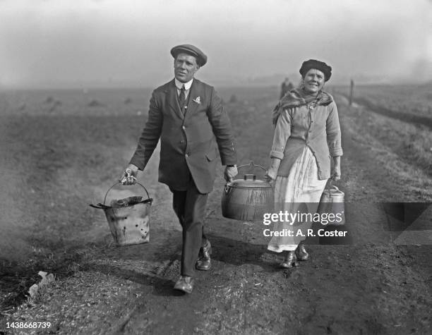 Man and woman carrying a cooking pot containing Lancashire hotpot to the course of the Waterloo Cup, a three-day coursing event held at Great Altcar...