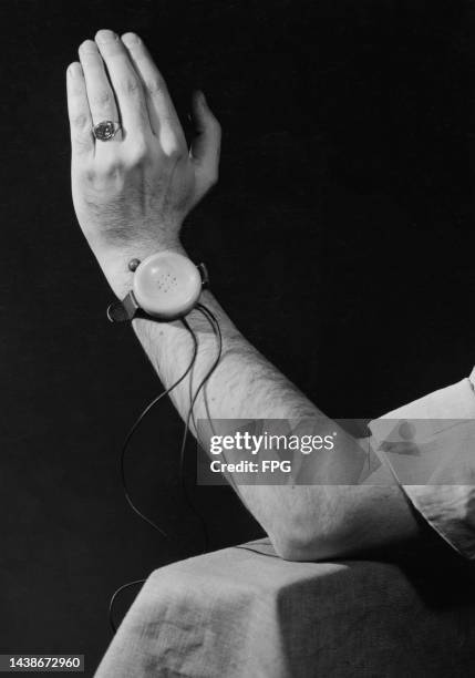 Man wearing the Dick Tracy Wrist Radio, a crystal set worn on the wrist with a strap, like a wristwatch, United States, March 1946. Manufactured by...