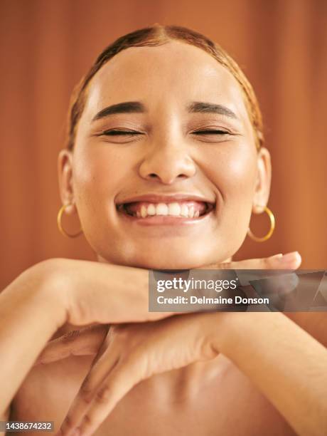 model, woman and smile in closeup portrait for makeup, skincare and natural with happiness. girl, skin and happy with hands by face for beauty, wellness and cosmetics against brown studio background - model smile stockfoto's en -beelden