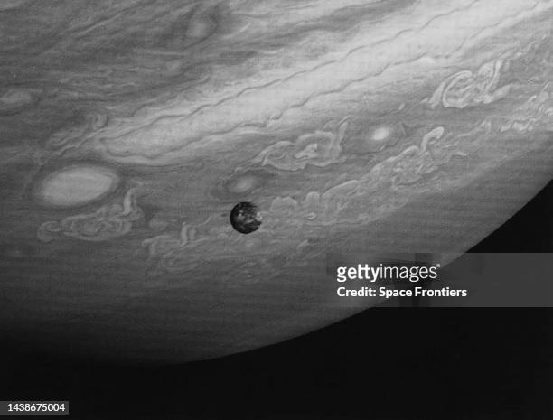 Io, the innermost of the large Galilean satellites of Jupiter, pictured from a distance of 12 million kilometers against Jupiter's southern...