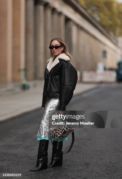 Sonia Lyson seen wearing Fendi animal print baguette bag, Jimmy Choo black boots, Twenty Fall dark brown leather jacket, Fendi sparkling midi skirt...