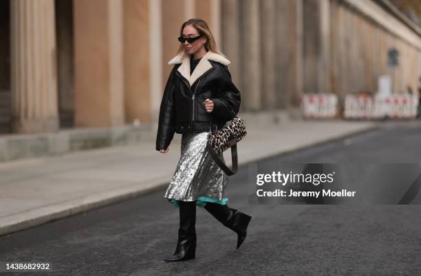 Sonia Lyson seen wearing Fendi animal print baguette bag, Jimmy Choo black boots, Twenty Fall dark brown leather jacket, Fendi sparkling midi skirt...