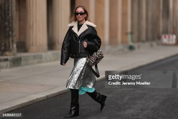 Sonia Lyson seen wearing Fendi animal print baguette bag, Jimmy Choo black boots, Twenty Fall dark brown leather jacket, Fendi sparkling midi skirt...