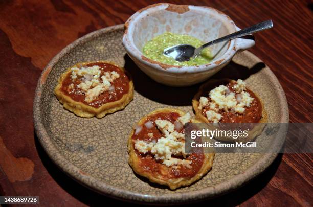 sopas con salsa roja, cebolla y queso de almendras y salsa verde (sopes with red sauce, onion and almond cheese and a side dish of salsa verde) - salsa queso stock pictures, royalty-free photos & images