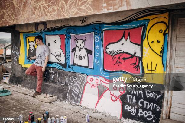 artist with his work - grafitti artist stock pictures, royalty-free photos & images