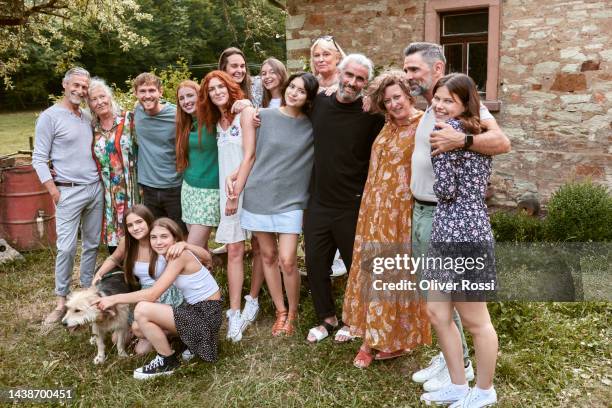 multi-generation family and friends posing in garden - large family - fotografias e filmes do acervo