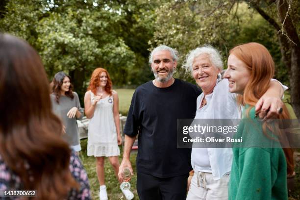 happy family and friends standing in garden - individual group stock-fotos und bilder