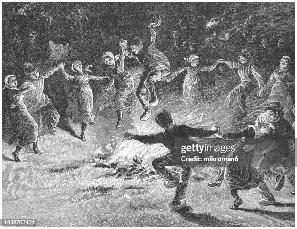 old engraved illustration of young people dancing around the fire at night - fuego al aire libre fotografías e imágenes de stock