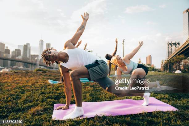 yoga outdoor class in new york - diverse exercise class stock pictures, royalty-free photos & images