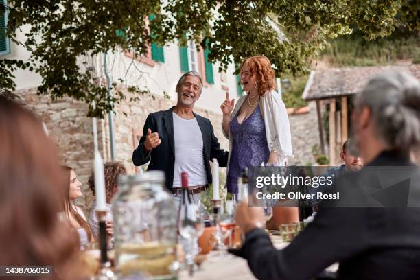 family and friends having on outdoor celebration - senior man dancing on table stock-fotos und bilder