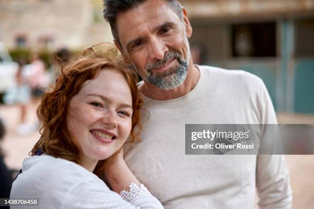 portrait of smiling father and adult daughter outdoors - old man young woman stockfoto's en -beelden