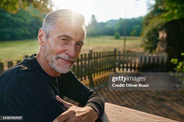portrait of a confident senior man outdoors at sunset - homme 60 ans portrait photos et images de collection