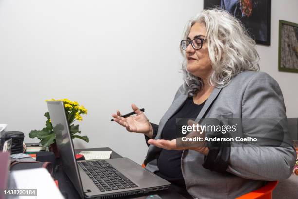 middle aged latin woman working from home - hot desking stock pictures, royalty-free photos & images