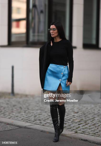 Leo Eberlin wearing Self Portrait blue shiny mini skirt, COS cotton black top, Zara black blazer, Jimmy Choo black leather overknees, Asos shades and...