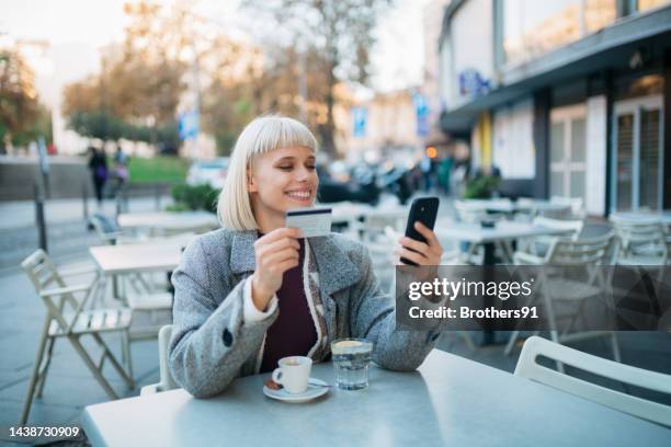 einkaufen online mit einem smartphone und einer kreditkarte, während sie in einem café sitzen - coffee shop chat stock-fotos und bilder