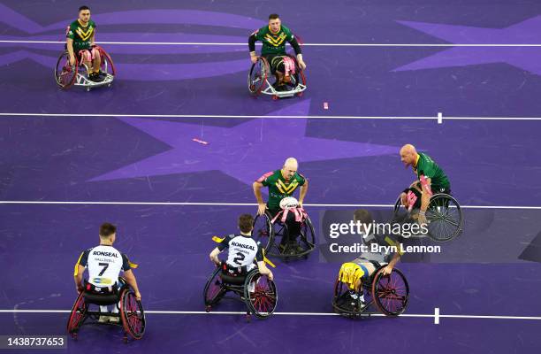 Brad Grove of Australia controls the ball while under pressure from Rob Hawkins and Joe Coyd of England during the Wheelchair Rugby League World Cup...