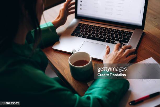 an unrecognizable business woman working on his laptop in the office - escribir fotografías e imágenes de stock