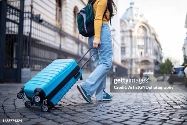 unrecognizable tourist walking on street with suitcase. - carry on luggage stock pictures, royalty-free photos & images