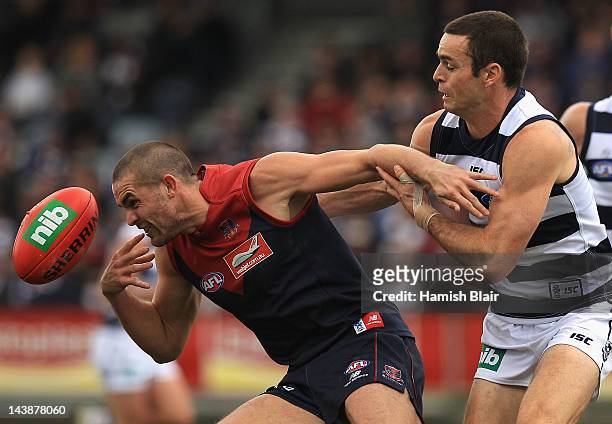 James Sellar of the Demons collects the ball under pressure from Matthew Scarlett of the Cats during the round six AFL match between the Geelong Cats...
