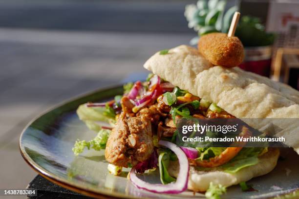 chicken sandwich on the plate and outdoor table. - doner kebab stockfoto's en -beelden