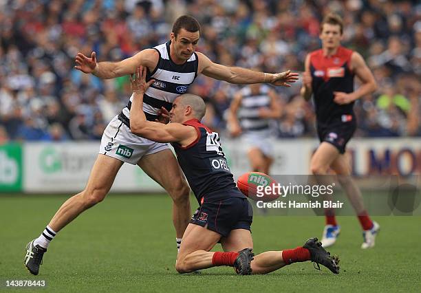 James Magner of the Demons tackles Matthew Scarlett of the Cats during the round six AFL match between the Geelong Cats and the Melbourne Demons at...