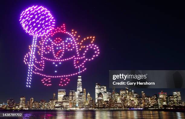 Character holding a lollipop is created by 500 drones over the skyline of lower Manhattan and One World Trade Center during an advertising promotion...