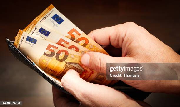 close-up of man's hand taking money out of a wallet - billet en euros photos et images de collection