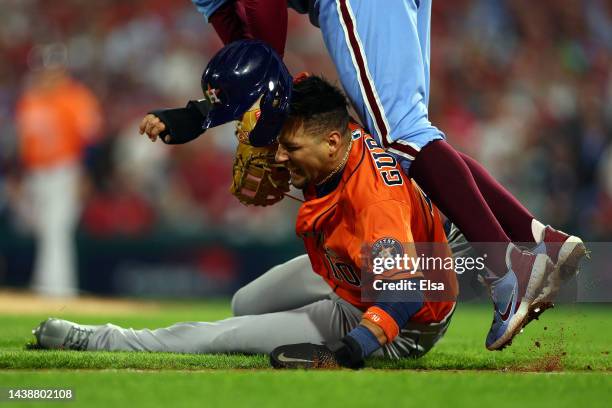 Yuli Gurriel of the Houston Astros is caught in a rundown and is tagged out by Rhys Hoskins of the Philadelphia Phillies during the seventh inning in...