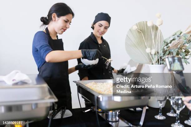 cocineros añadiendo queso a los alimentos - petite latina fotografías e imágenes de stock