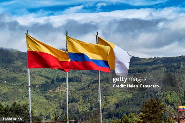 flag of colombia waving in the wind against monserrate hill. colombia - monserrate bogota stock pictures, royalty-free photos & images