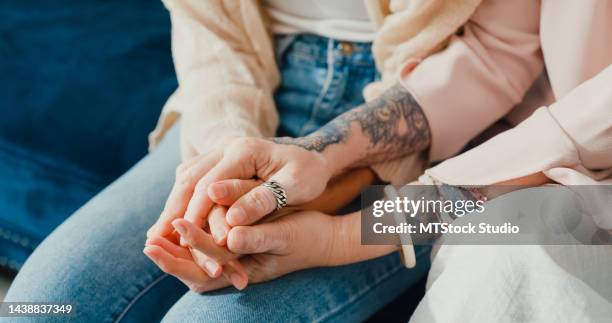 close-up asian retirement senior mother sit on cozy sofa couch with depression sad sickness daughter, mom cover and hold her hand supporting each other at home. - frustration concept stock pictures, royalty-free photos & images
