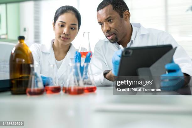 laboratory testing petroleum and chemicals in oil industry. a diversity of chemists has discussed their research on chemical solution samples in a laboratory. - physics experiment stock pictures, royalty-free photos & images