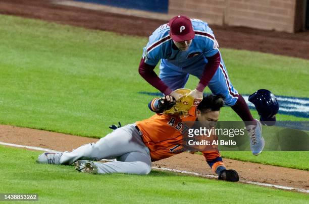 Yuli Gurriel of the Houston Astros is caught in a rundown and is tagged out by Rhys Hoskins of the Philadelphia Phillies during the seventh inning in...