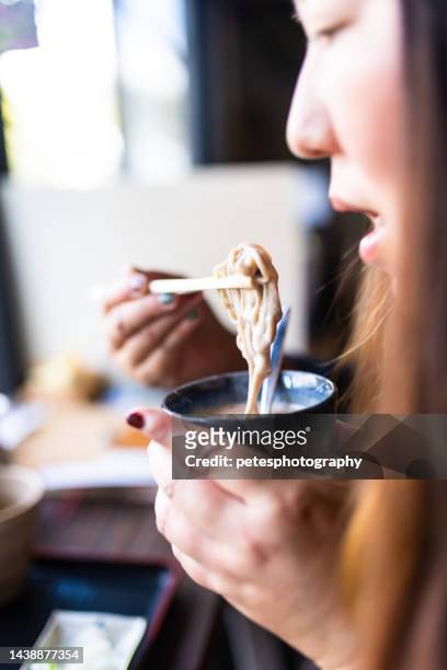 una mujer comiendo soba en un restaurante de fideos japoneses - prefectura de iwate fotografías e imágenes de stock