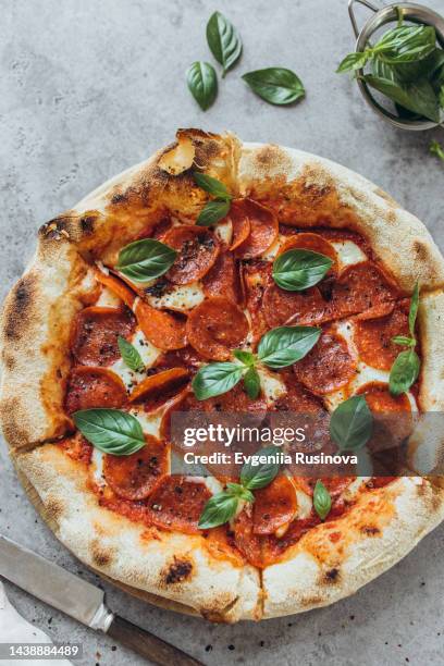 pepperoni pizza garnished with basil leaves - parmesan cheese pizza stock pictures, royalty-free photos & images
