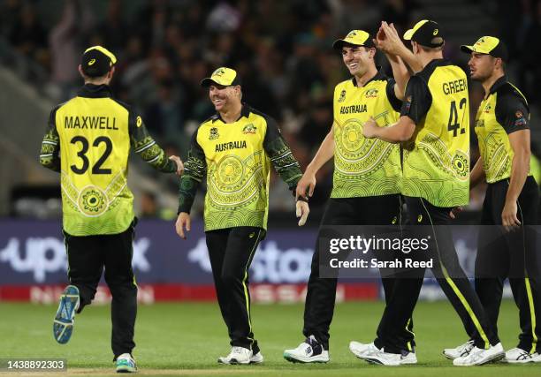 Patrick Cummins of Australia surrounded by team mates after he took the catch to dismiss Usman Ghani of Afghanistan for 2 runs off the bowling of...