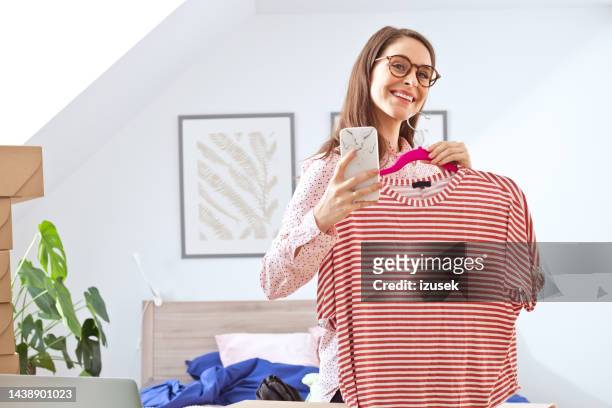 woman selling her clothes online - photographing clothes stock pictures, royalty-free photos & images