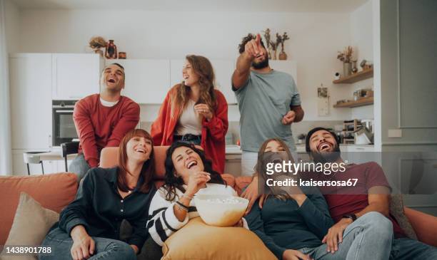gruppe von freunden, die einen lustigen film fernsehen, popcorn essen und lachen - friends tv show stock-fotos und bilder