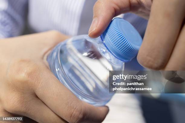 close up hand twist the bottle cap to open. - bottle cap stock pictures, royalty-free photos & images