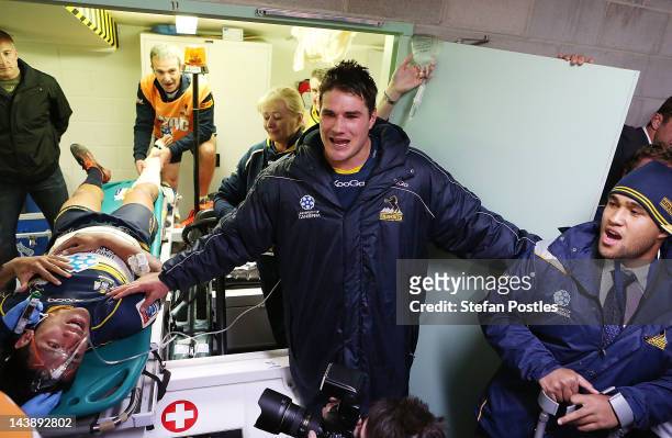 Brumbies players gather around injured Chirstian Lealiifano to sing the team song during the round 11 Super Rugby match between the Brumbies and the...