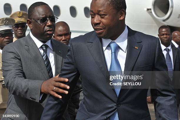 Senegalese President Macky Sall flanked by Togolese President Faure Gnassingbe walk at the tarmac of Dakar airport on May 3 upon arrival for the...