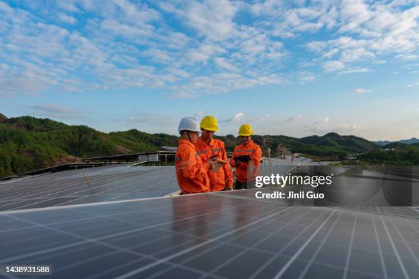 solar panels on the top of the mountain, three workers are studying and discussing - development summit stock pictures, royalty-free photos & images