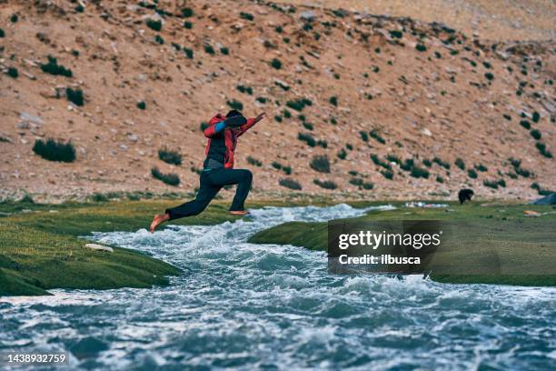 barefoot man jumping small river, ladakh region, india - leh stock pictures, royalty-free photos & images